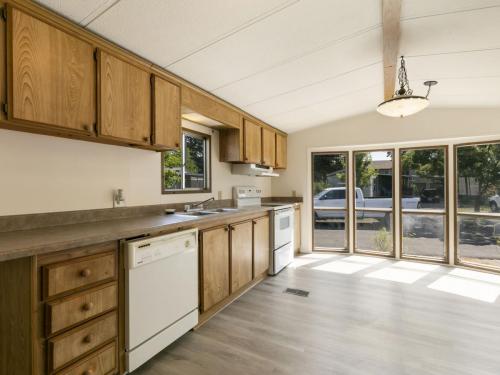 An empty kitchen with wood cabinets and a window.