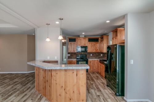 A kitchen with wood cabinets and hardwood floors.