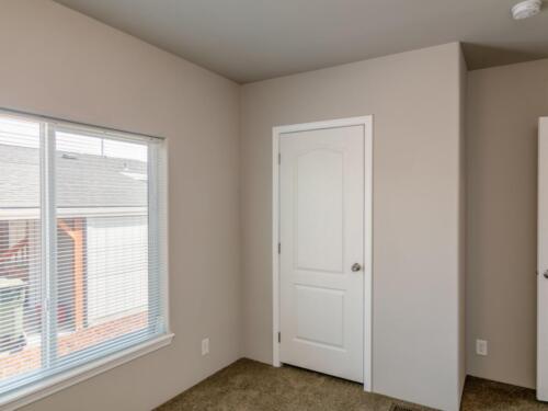 An empty room with two doors and a window.